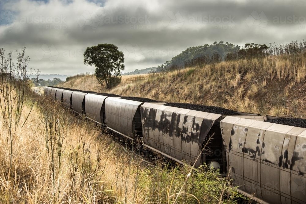 End of a coal train passing on a cloudy morning - Australian Stock Image