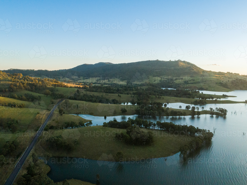 end of the day sunlight over Glennies creek dam water supply seen from aerial view - Australian Stock Image