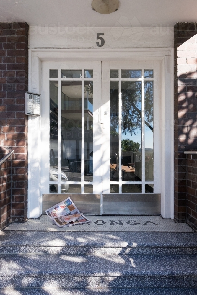 image of entrance to mid century apartment building with magazine by