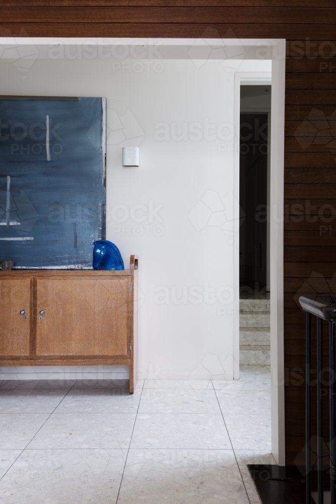 Entry foyer buffet and artwork viewed from living area in mid century modern home - Australian Stock Image