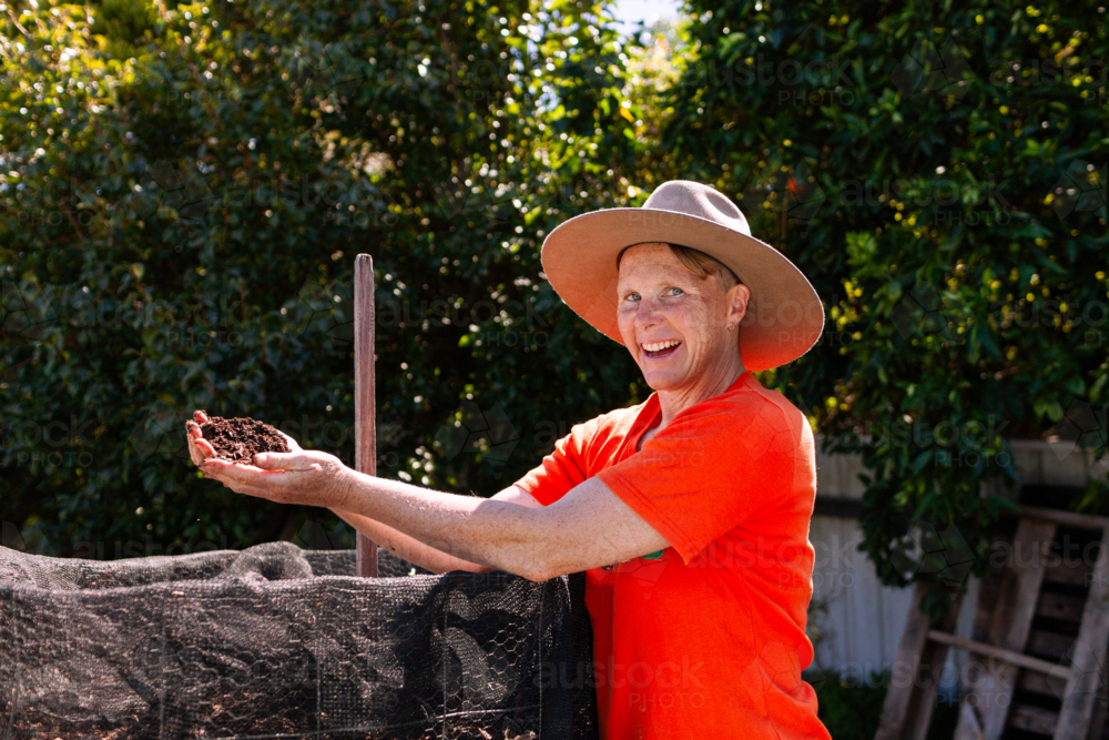 environmentalist composting advocate woman holding dirt made in garden compost system - Australian Stock Image