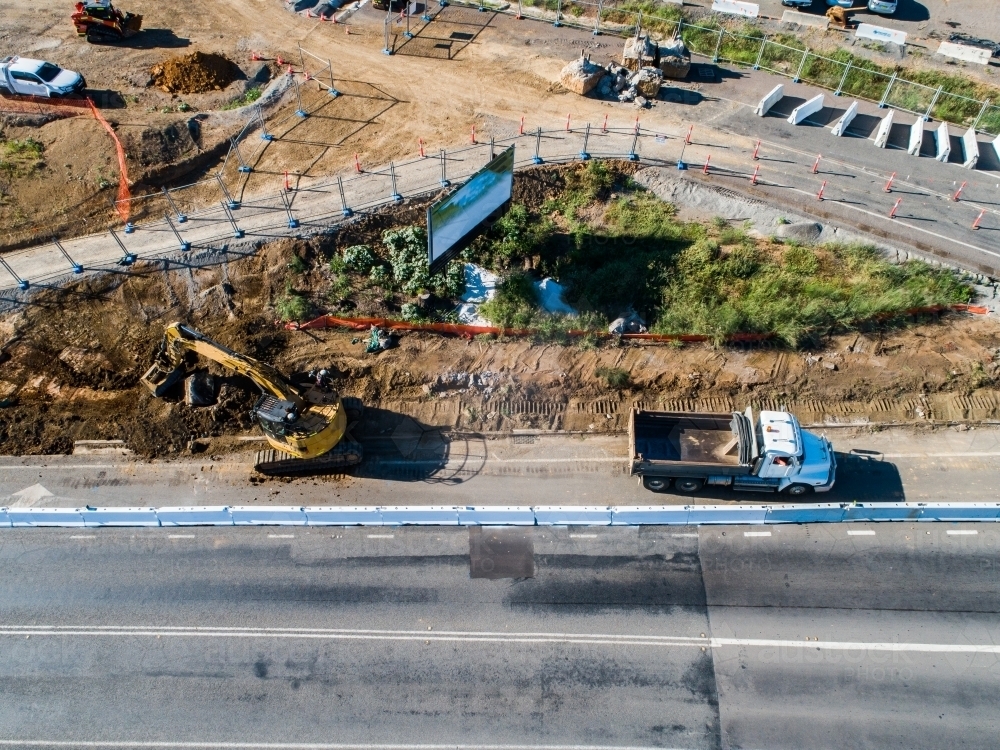Excavator loading dirt into truck at worksite - Australian Stock Image