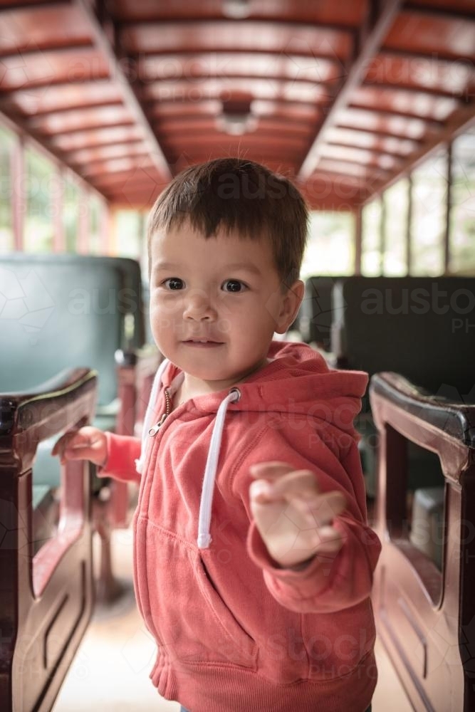 Excited 2 year old mixed race boy cheerfully rides the Walhalla historic train - Australian Stock Image