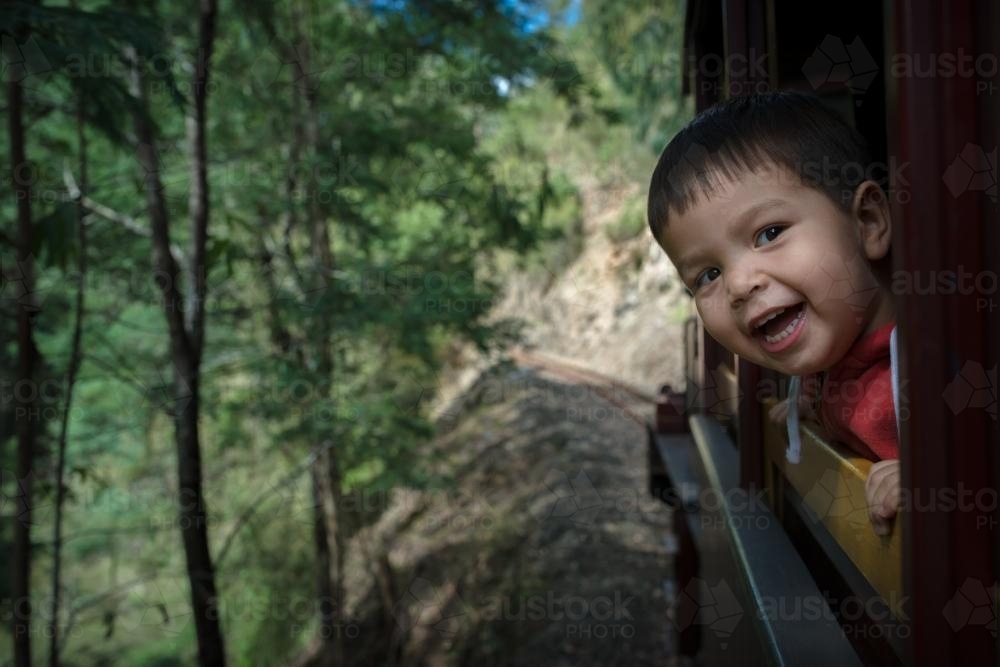 Excited 2 year old mixed race boy cheerfully rides the Walhalla historic train - Australian Stock Image