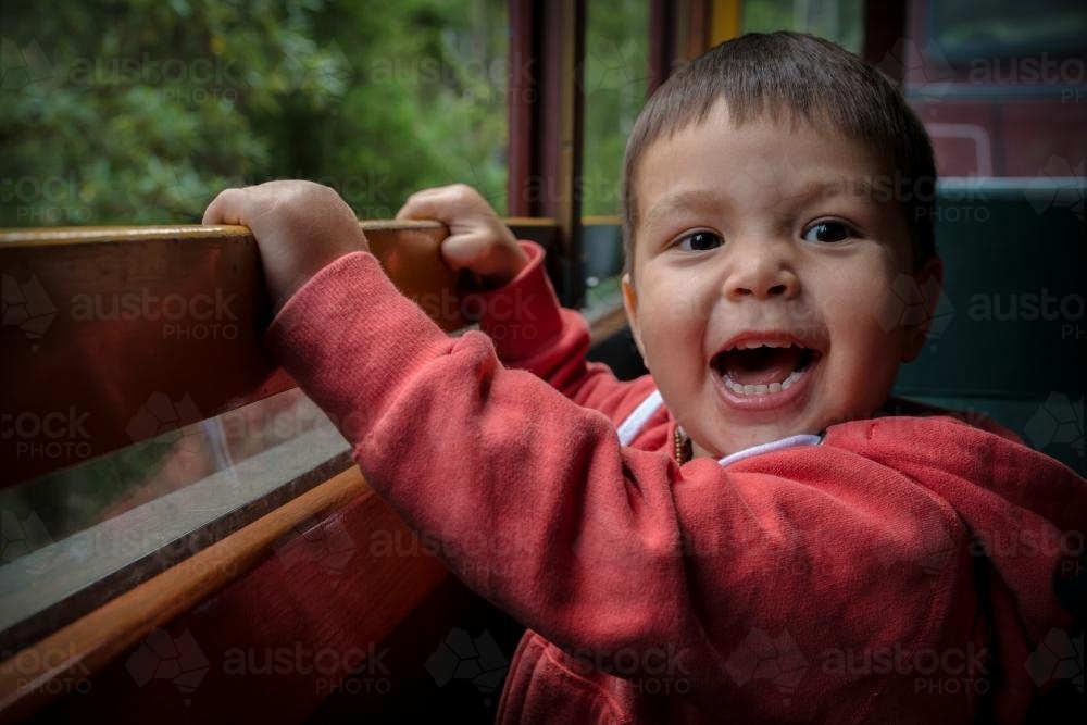 Excited 2 year old mixed race boys cheerfully rides the Walhalla historic train - Australian Stock Image
