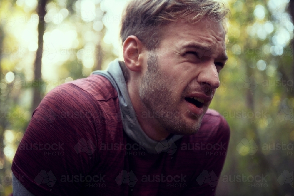 Exhausted man catching breath on Morning Run in the Woods / Forest / Bush - Australian Stock Image