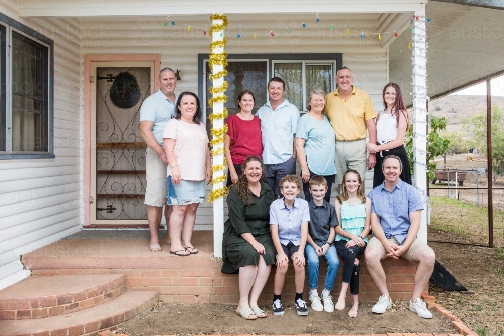Extended family happy smiling on front verandah of house - Australian Stock Image