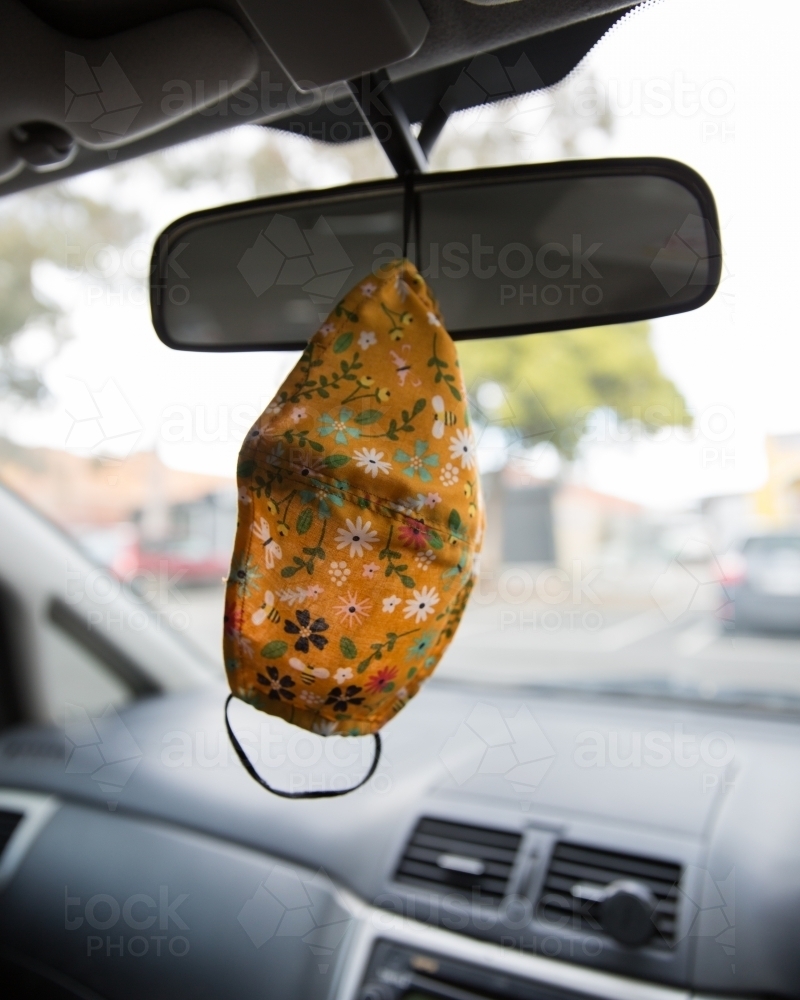 Face Mask Hanging From a Rear View Mirror - Australian Stock Image