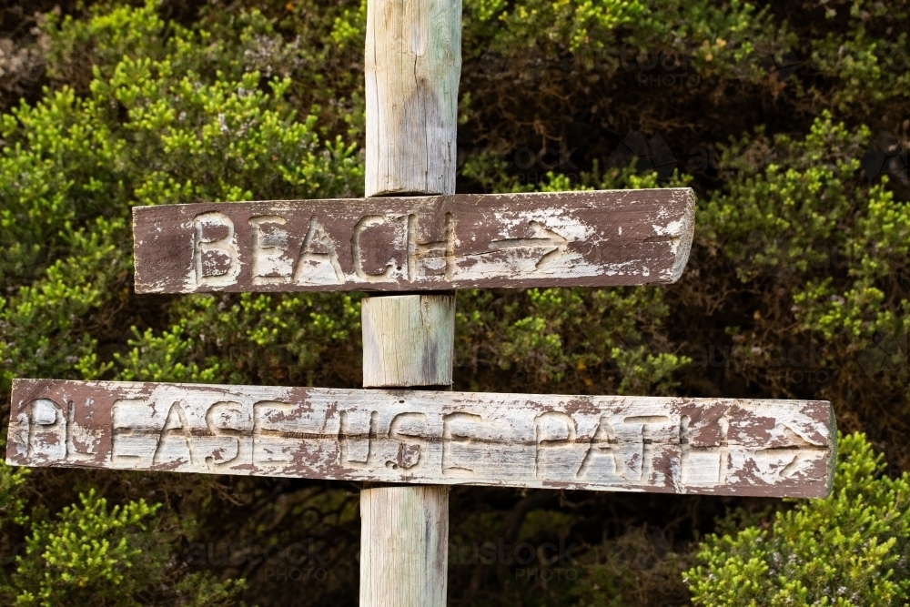 Faded rustic wooden sign pointing to beach - Australian Stock Image