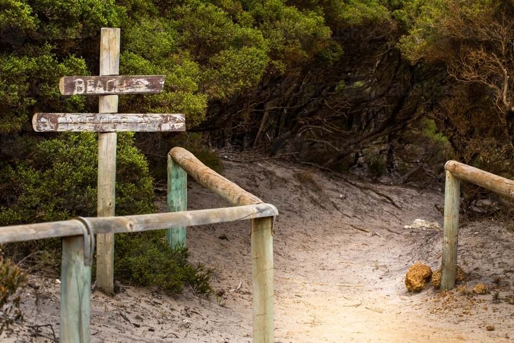Faded sign pointing the way to a secluded beach - Australian Stock Image