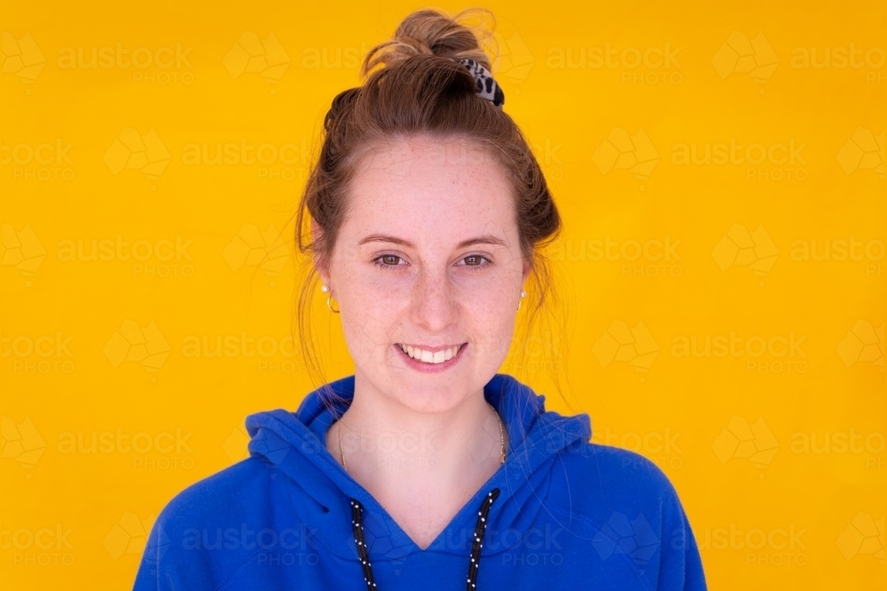 fair skinned young woman with messy bun head and shoulders - Australian Stock Image