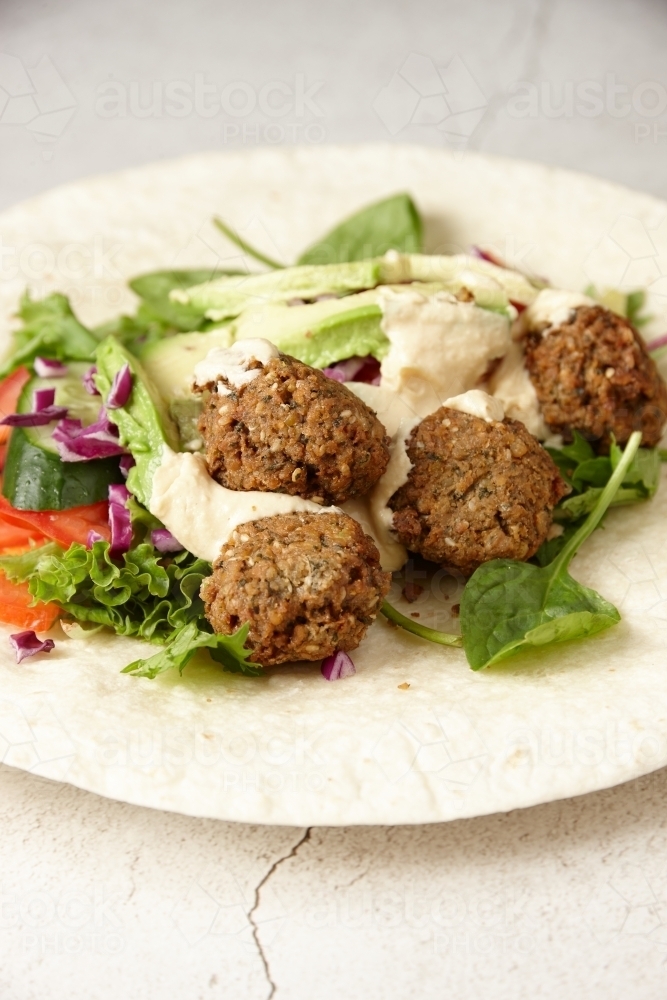 Falafel wraps with meatballs, vegetables, and dressing : Austockphoto Falafel wraps with meatballs, vegetables, and dressing - Australian Stock Image