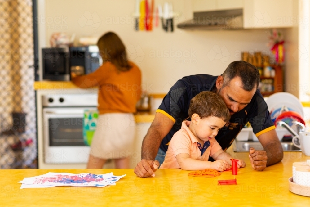 Family at home in kitchen with toddler and parents - Australian Stock Image