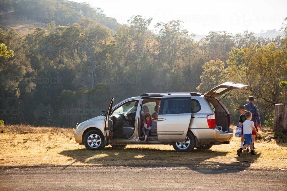 Family getting out of car stopped on the roadside for a break - Australian Stock Image