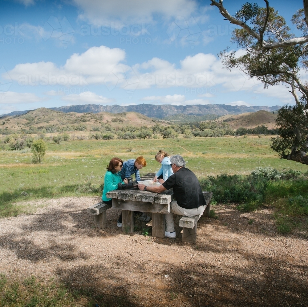 Family having a rest at a wooden table in the outback - Australian Stock Image