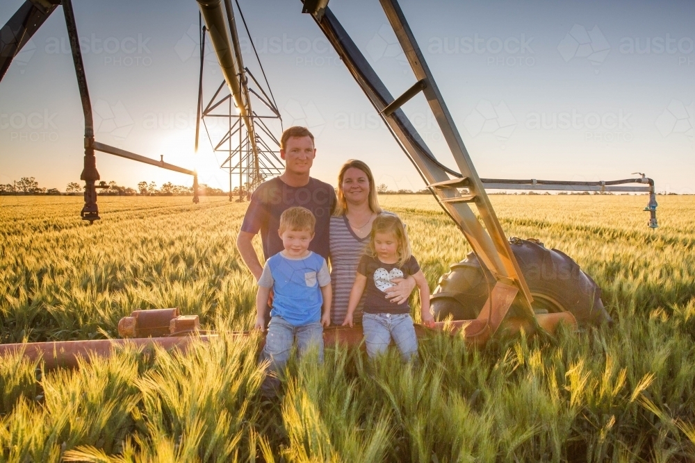 Family in wheat field paddock with pivot irrigation system - Australian Stock Image