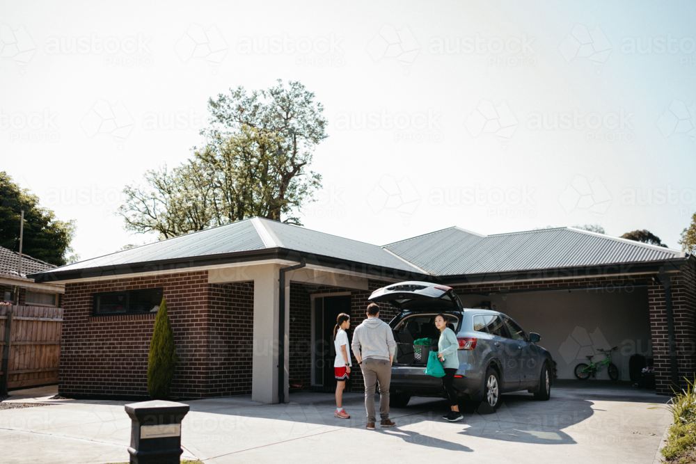 Family loading things into the boot of the car - Australian Stock Image
