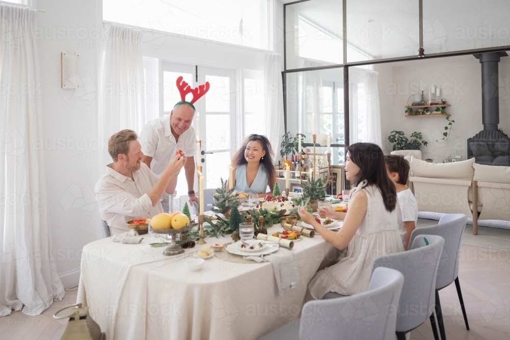Family of five sitting around Christmas table - Australian Stock Image