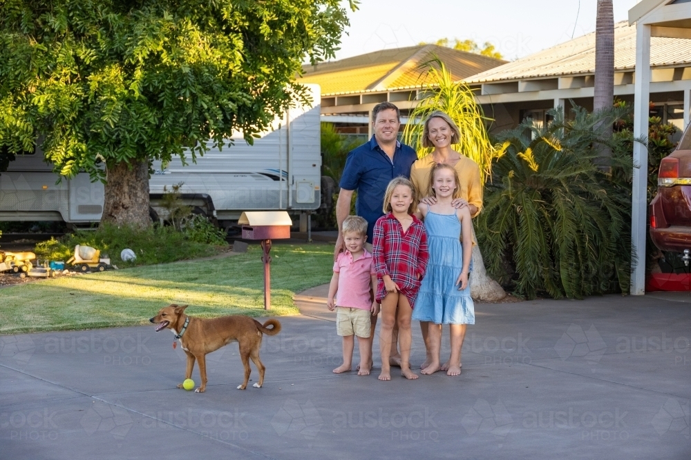 Family of five with pet dog in front of suburban home - Australian Stock Image
