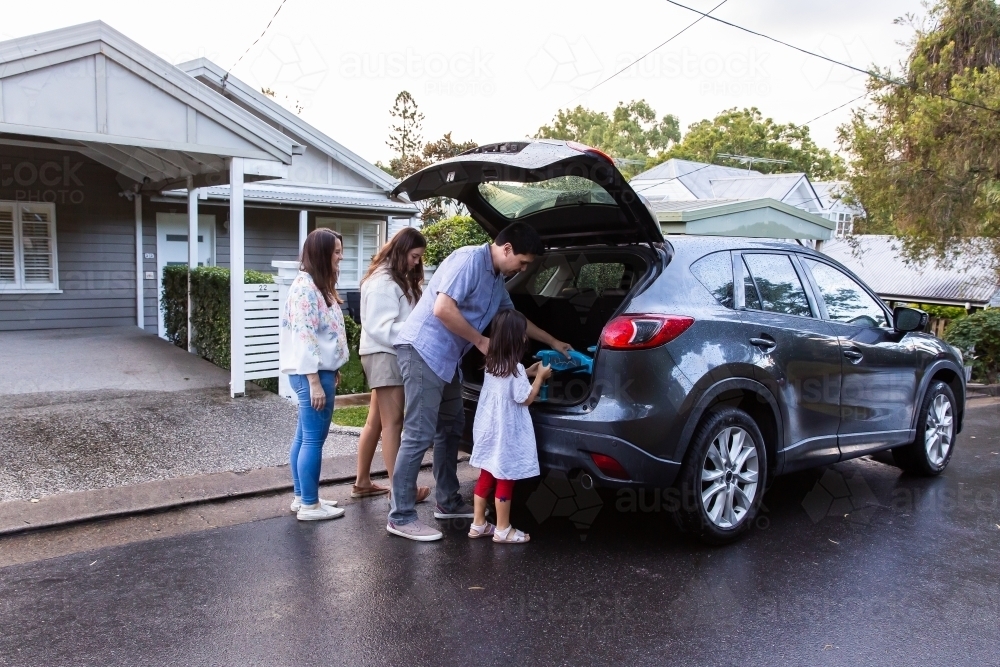 Loading Things Fun Image of Family of four loading things inside the car boot for trip to ...