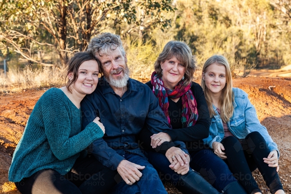 Family of four with teen and adult daughters siting together - Australian Stock Image
