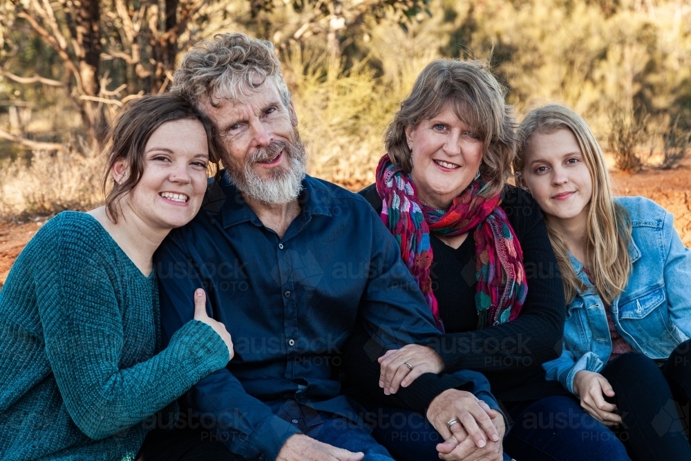 Family of four with teen and adult daughters siting together - Australian Stock Image
