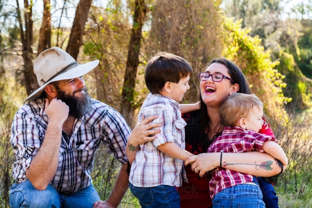 Family of four with two boys smiling together - Australian Stock Image