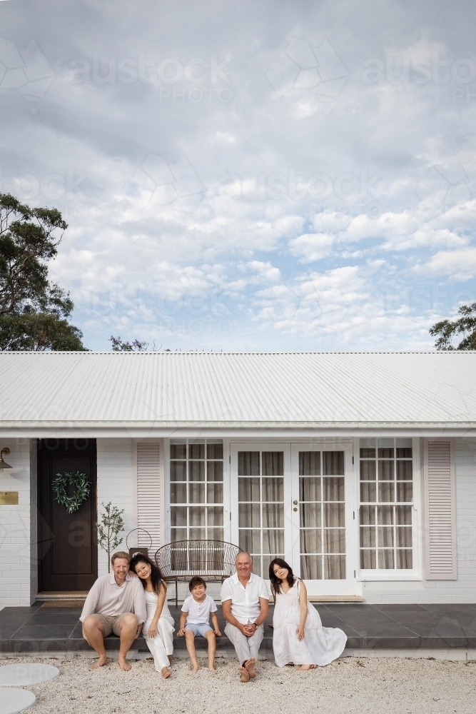 Image of Family of three generations sitting together on front deck of ...