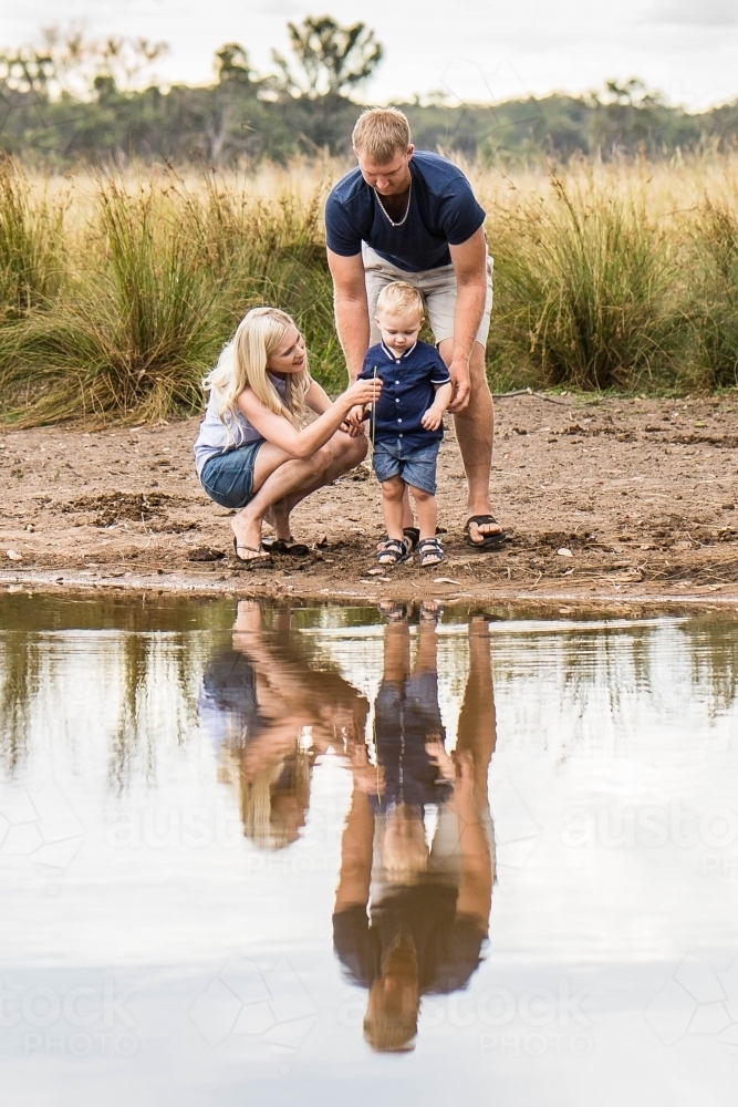 Family on farm looking at water in dam - Australian Stock Image
