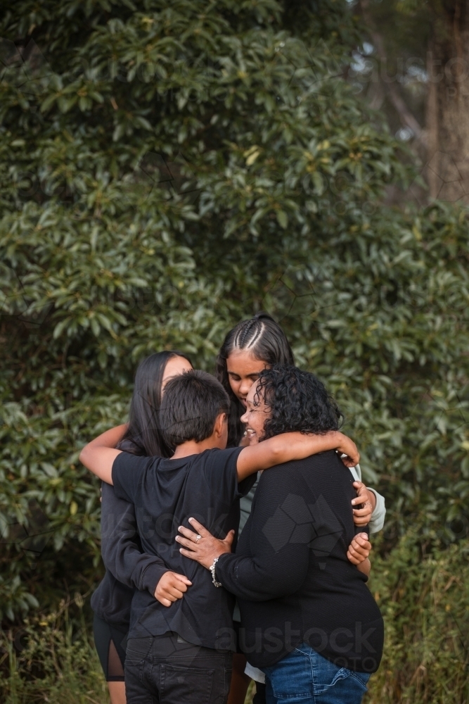 Family or friends sharing a group hug - Australian Stock Image