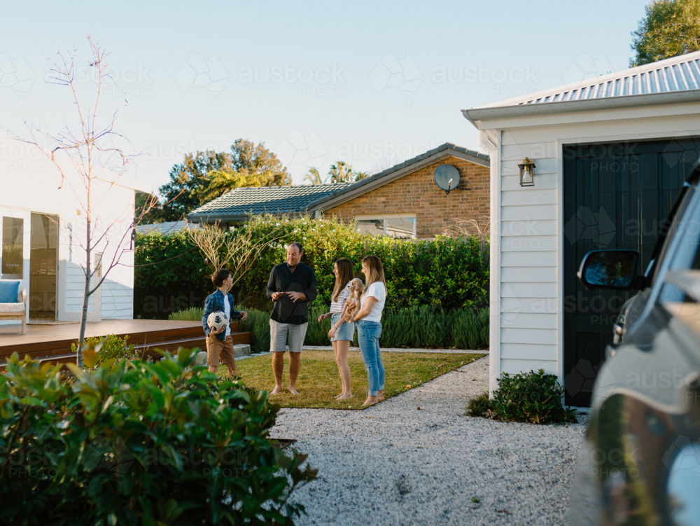 Family outside their house in the garden. - Australian Stock Image