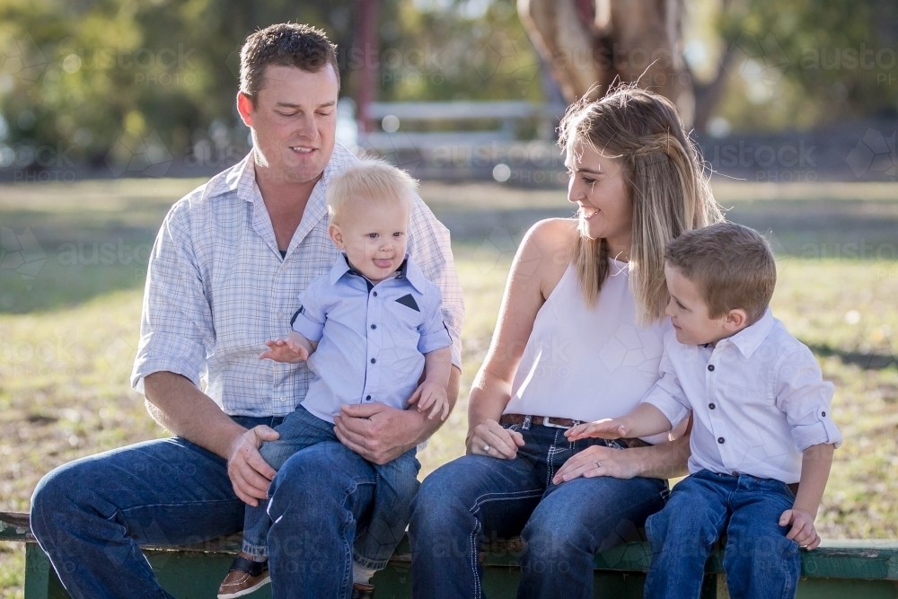 Family sitting together laughing at young child - Australian Stock Image