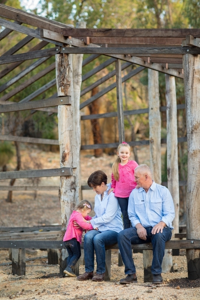 Family sitting together on timber frame of construction project - Australian Stock Image