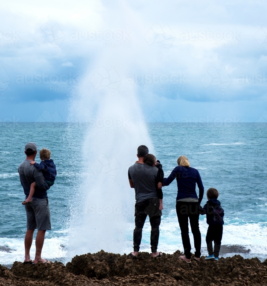 Family standing overlooking Blowholes on Ocean Cliffs - Australian Stock Image