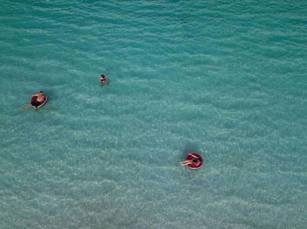 family swimming in clear blue water - Australian Stock Image