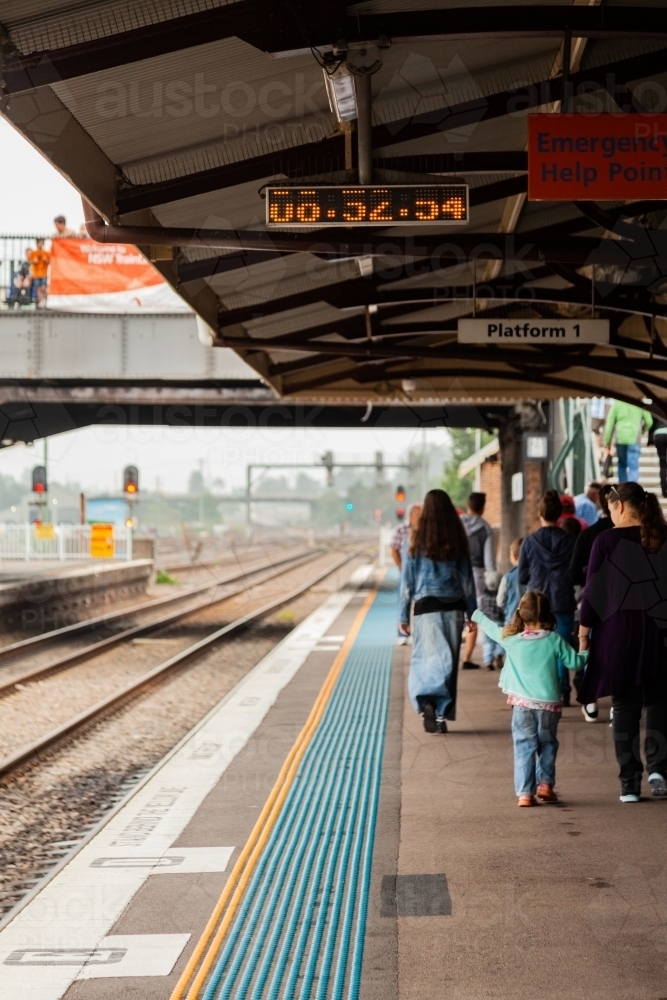 Family walking along platform at train station - Australian Stock Image
