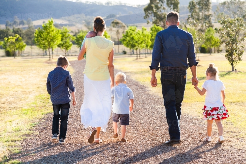 Family walking down driveway of farm - Australian Stock Image