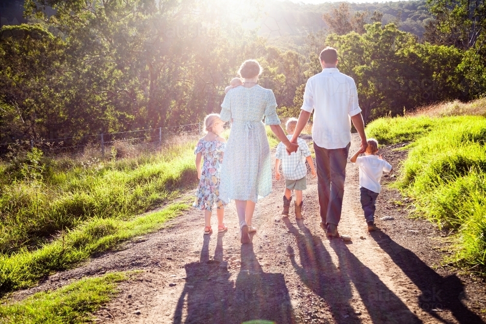 Family walking down farm driveway together - Australian Stock Image