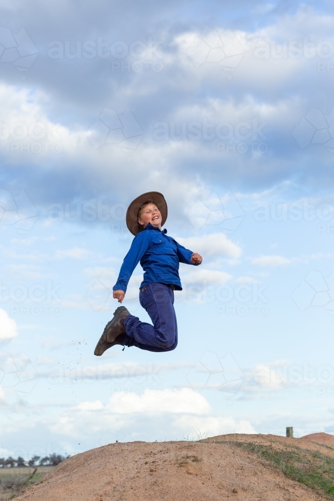 Farm boy jumping in the air - Australian Stock Image