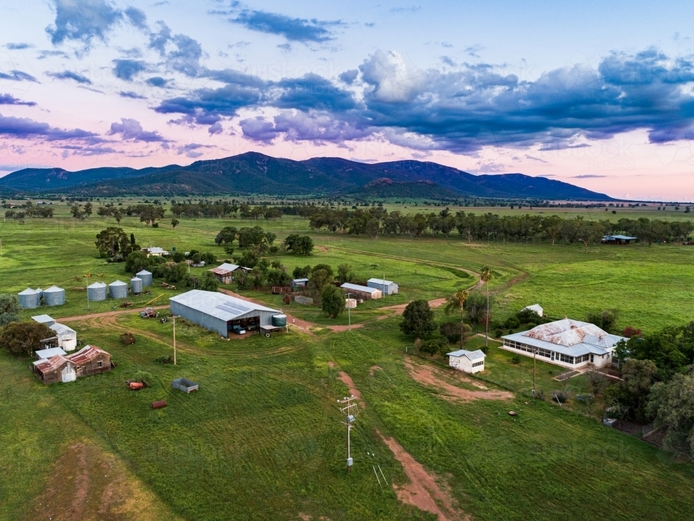 farm buildings and sheds at dusk hills in the background - Australian Stock Image