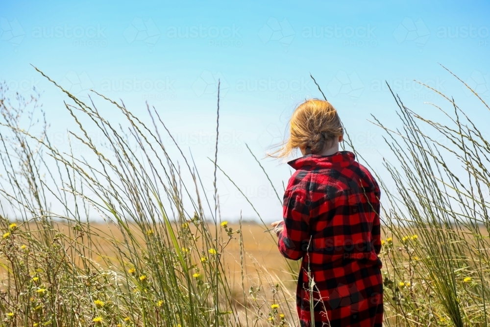 Farm girl in long grass on rural property - Australian Stock Image