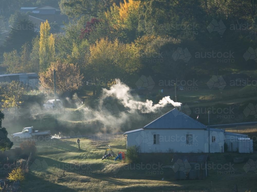 Farm house with smoke coming from chimney - Australian Stock Image