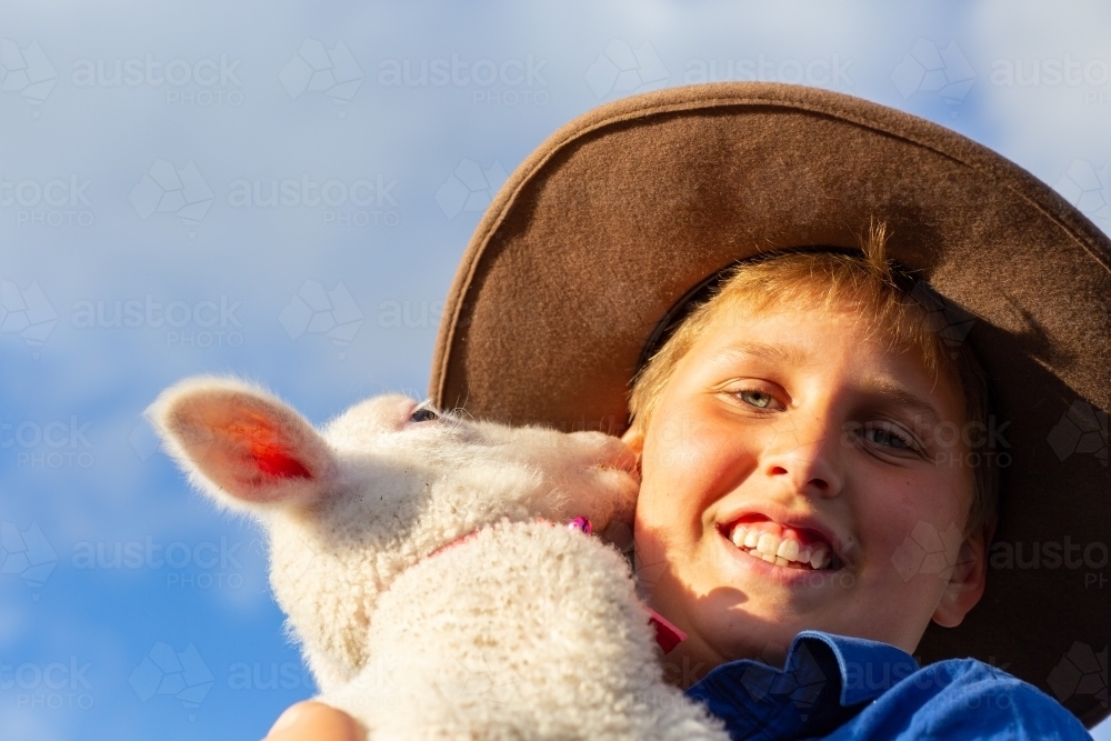 Farm kid with his pet lamb - Australian Stock Image