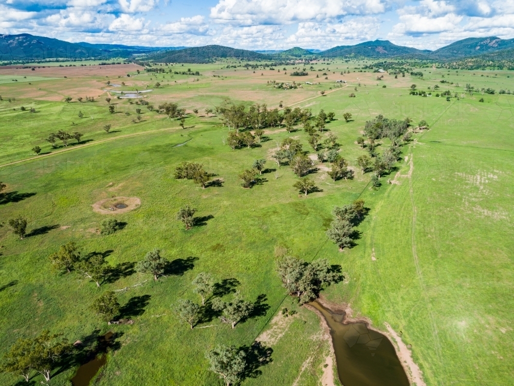 Farm landscape with dam and sunlit paddocks from the air - Australian Stock Image