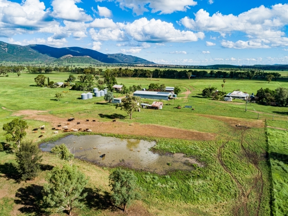 Farm landscape with dam and sunlit paddocks from the air - Australian Stock Image