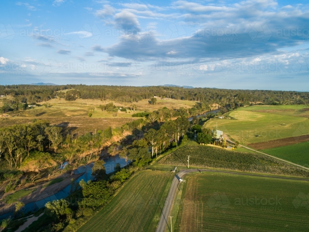 Farm paddocks beside hunter river in afternoon sunlight in summer - Australian Stock Image
