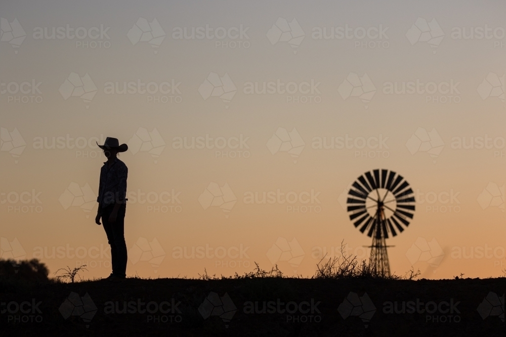 Farmer and windmill silhouette - Australian Stock Image