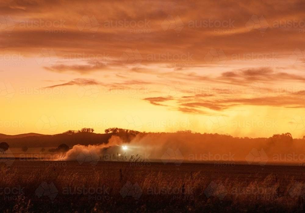 farmer harvesting at sunset - Australian Stock Image