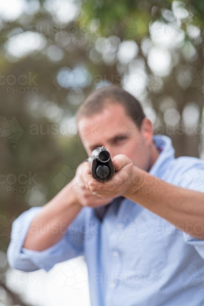 farmer holding a rifle towards camera - Australian Stock Image