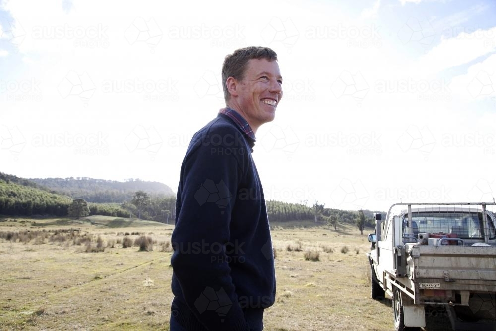 Farmer smiling looking away at his land - Australian Stock Image